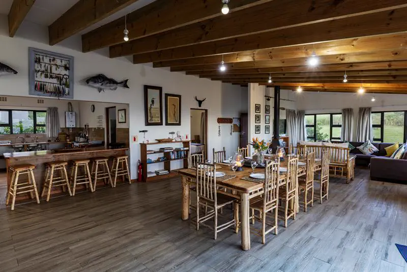 Open-plan dining room with long wooden table and bar counter