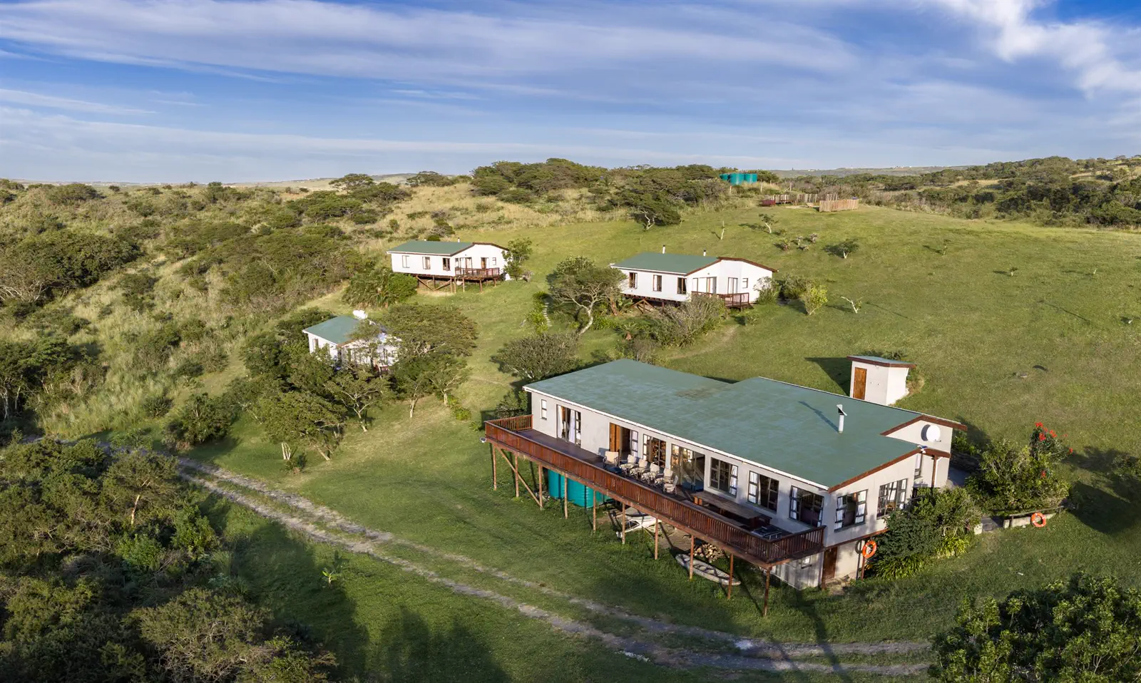 The Fish Eagle main house with its long deck, set in green grassland